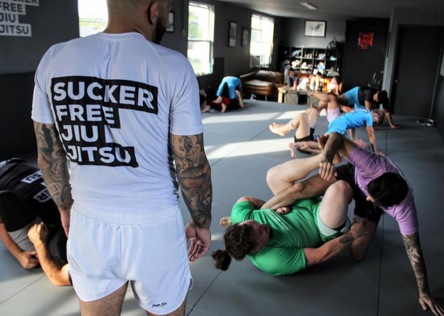 Coach Weiss watches a full class session after teaching a technique. He's wearing the signature SFJJ all-white fit